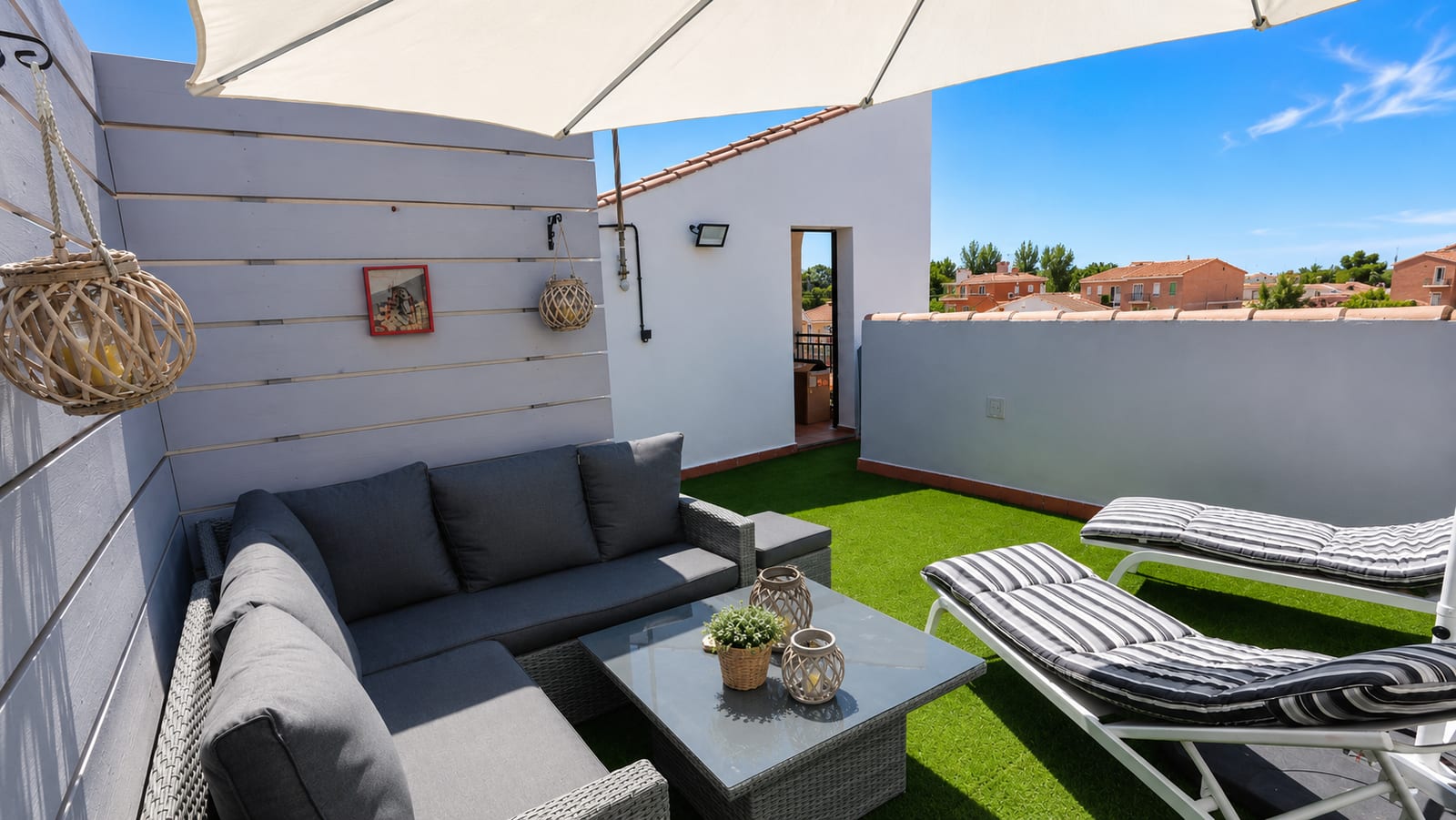 Eigen dakterras van Casa Feliz met loungeset, ligbed en kunstgras
