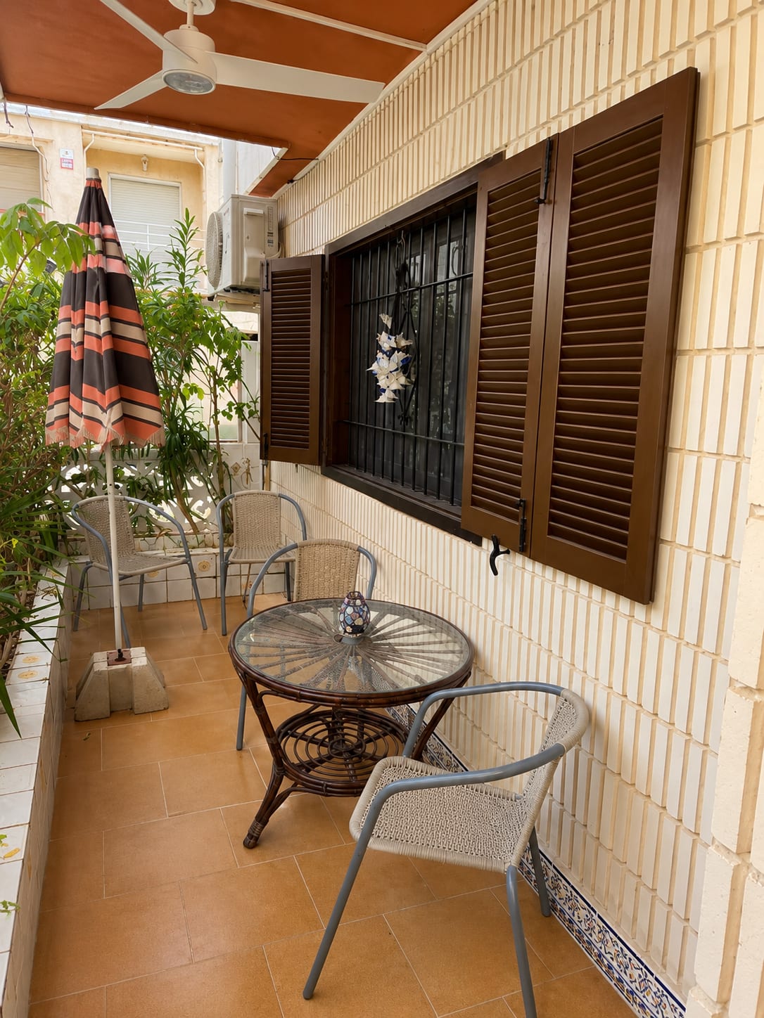 Vordere Terrasse der Casa Flamingo mit Tisch und Sonnenschirm